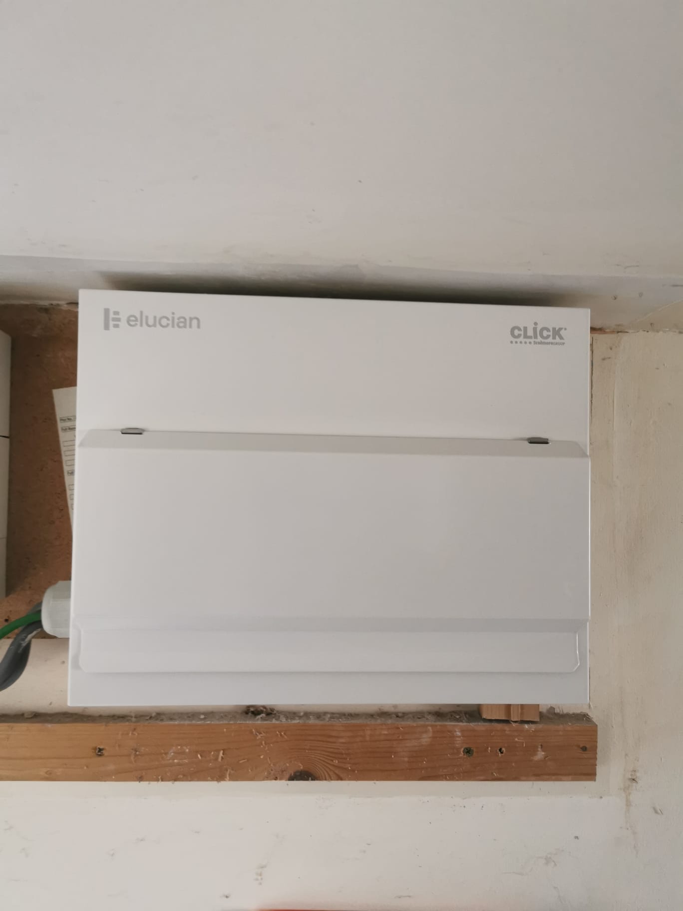 A new Elucian consumer unit, cover closed, fitted on a timber batten