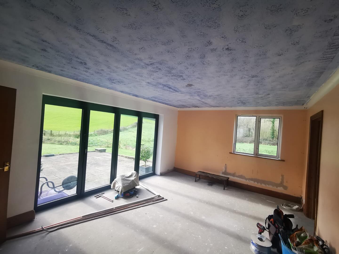 Empty room with bifold doors before the kitchen went in