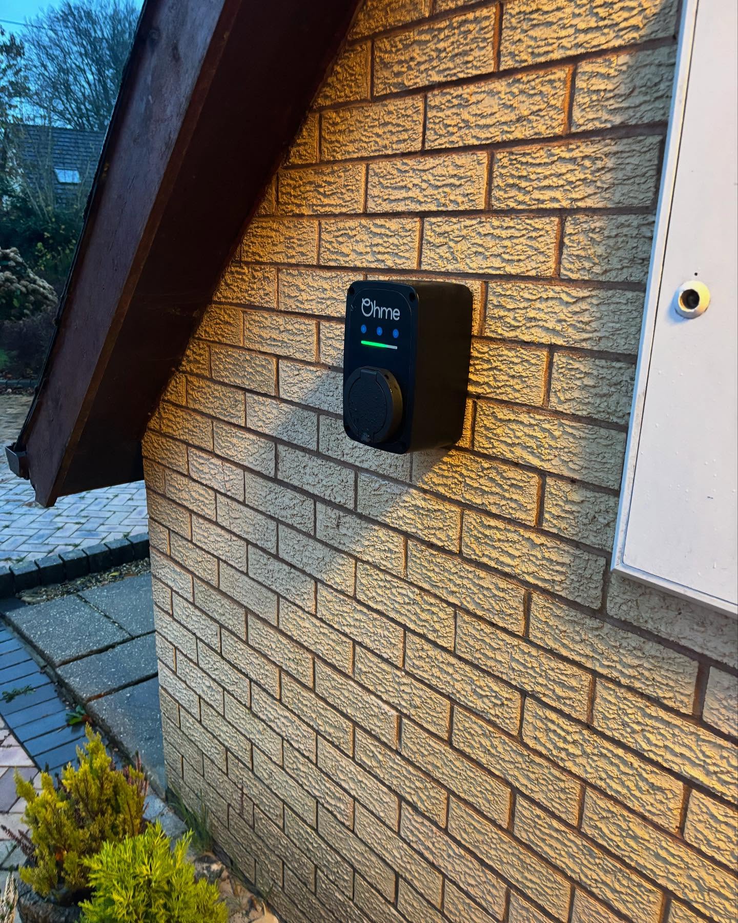 Ohme ePod EV charger fitted on a brick wall