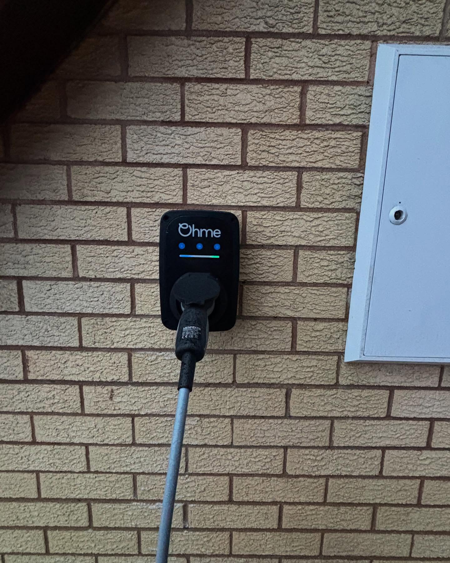 The Ohme ePod with its charging cable plugged in